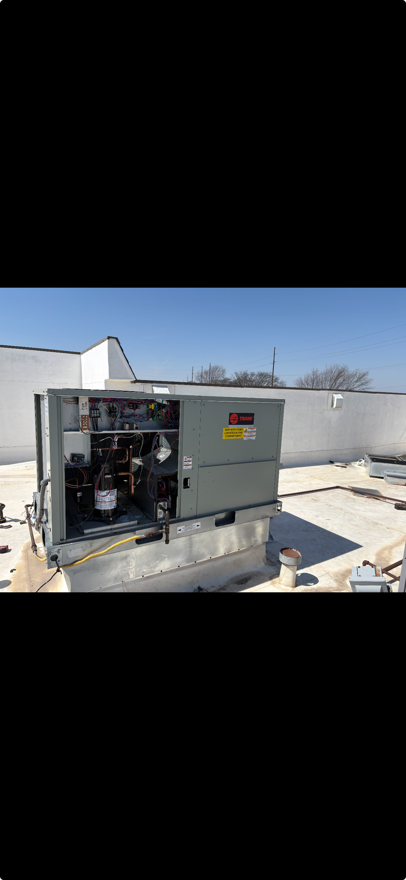 Trane rooftop HVAC unit with service panel open.